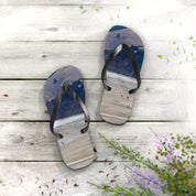 Flip-flops with a beach scene print on wooden planks.
