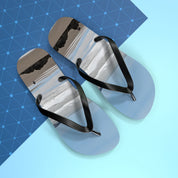 Flip-flops with abstract beach scene design and black straps on blue background.