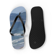 Flip-flops with a beach scene on the soles and textured black rubber on the other.