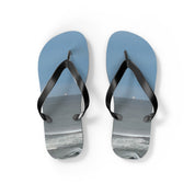 Blue flip-flops with a beach scene printed on the soles.