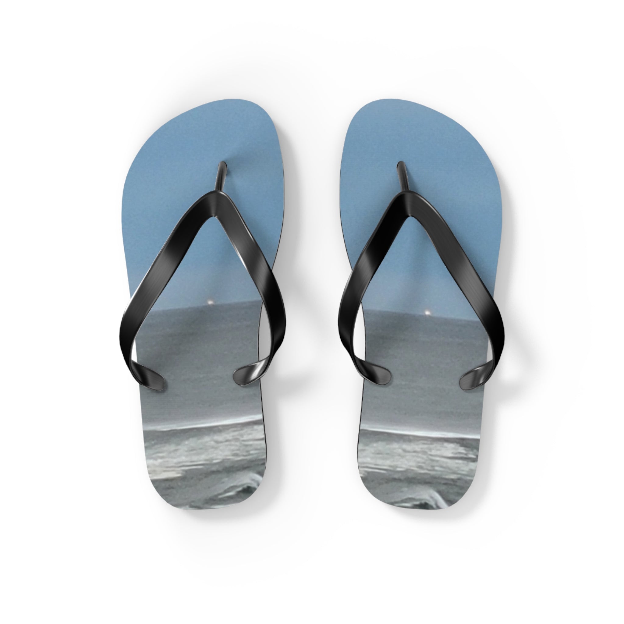 Blue flip-flops with a beach scene printed on the soles.