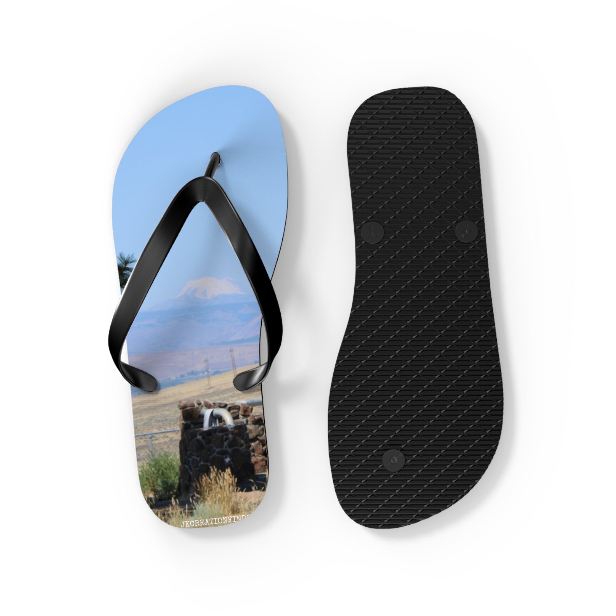 Flip-flops with a scenic mountain landscape and stone fountain on the soles.