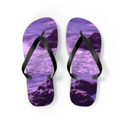 Purple flip-flops with a rocky ocean wave design on a white background.