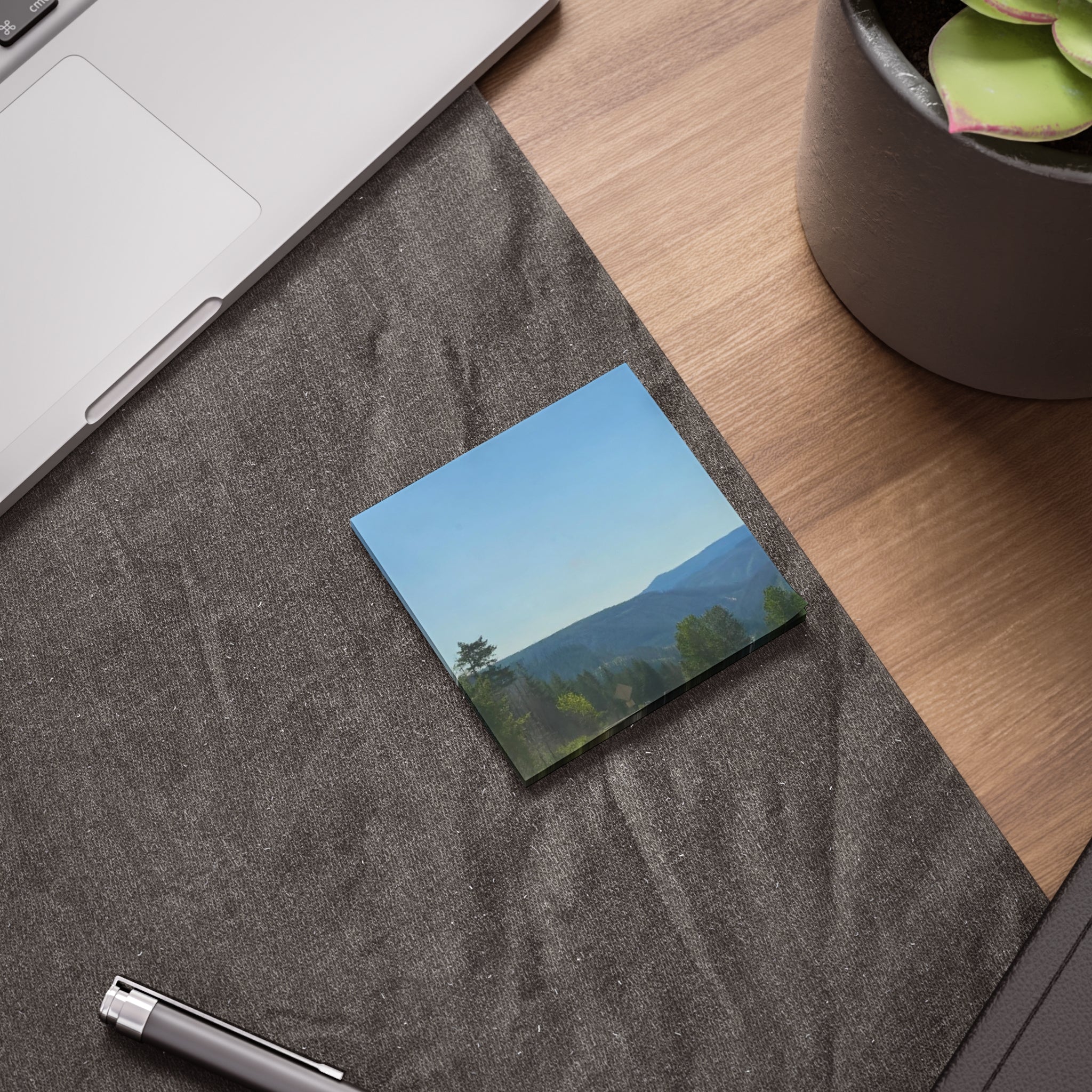 Scenic mountain landscape with trees on a sticky note.