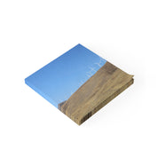Isometric view of a wind farm on a hillside with blue sky.