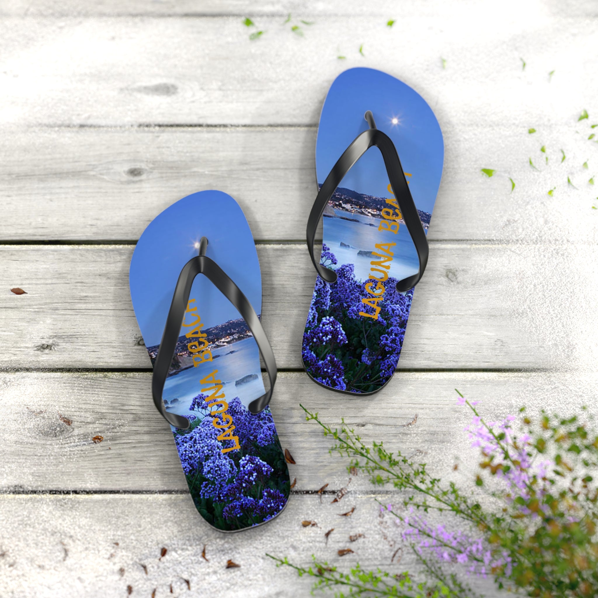 Flip-flops with a scenic night view of Laguna Beach and purple flowers.