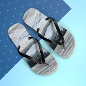 Pair of black and white marbled flip-flops on a blue background.