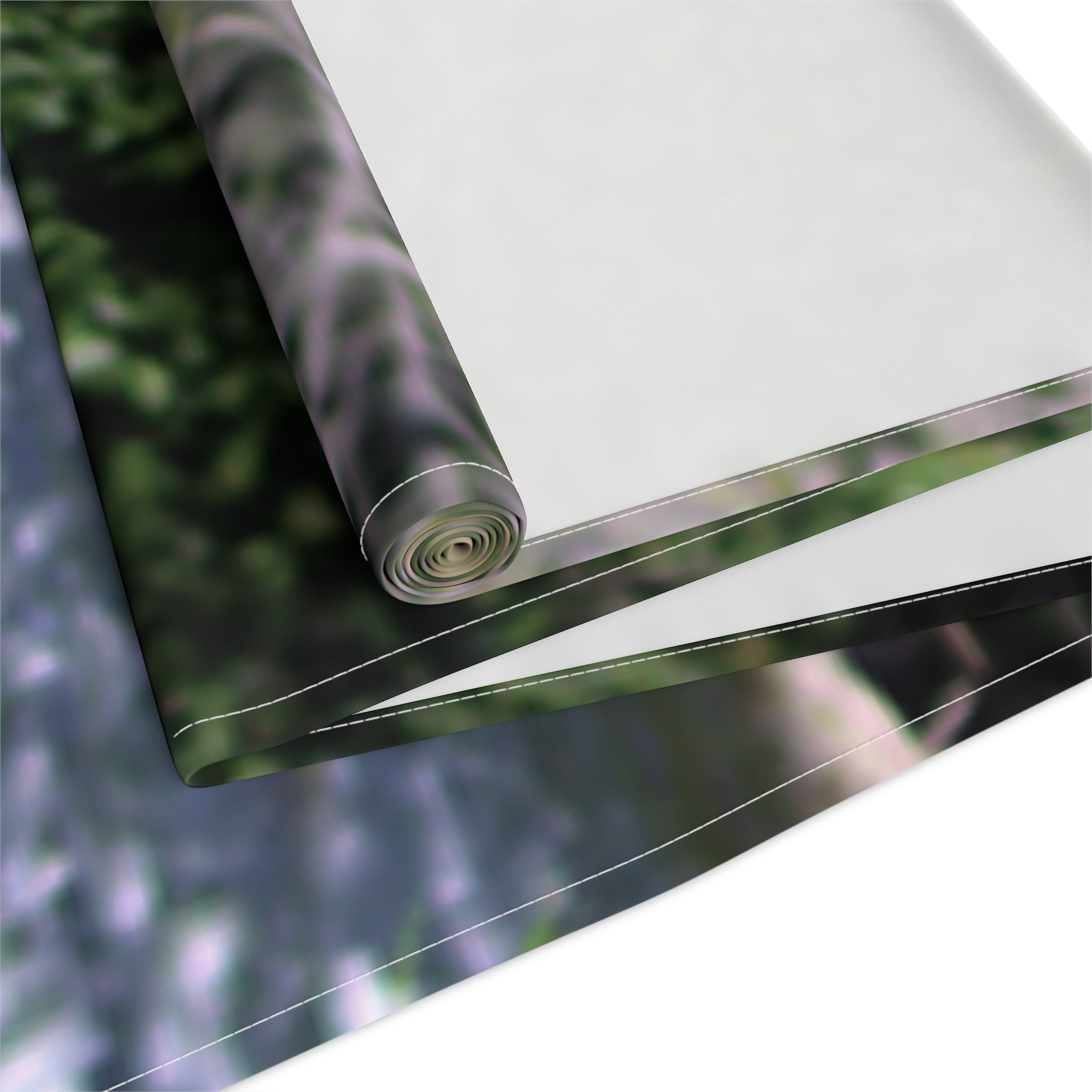 Rolled fabric with a blurred green and purple forest background.