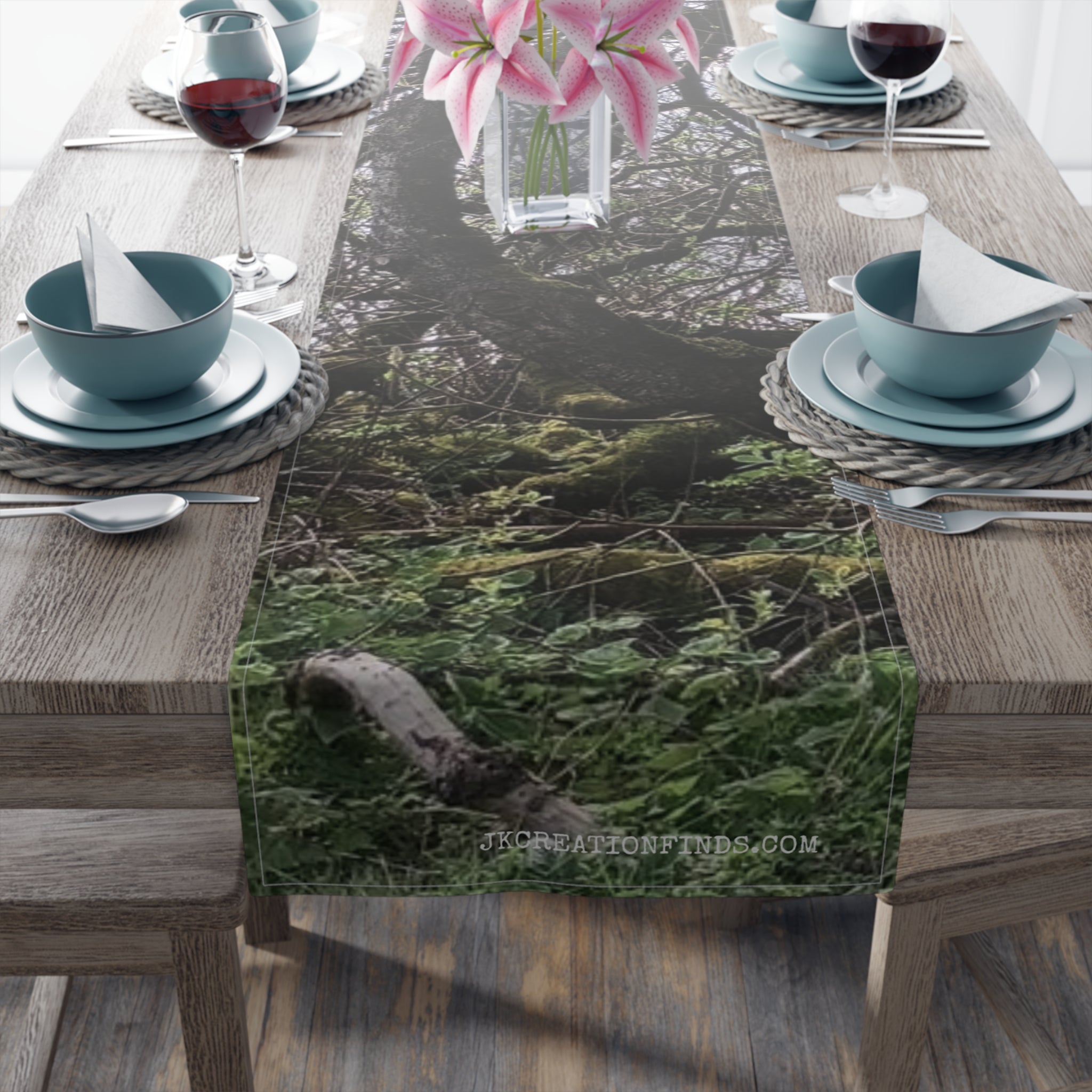 Forest table runner with pink flowers and mossy branches.