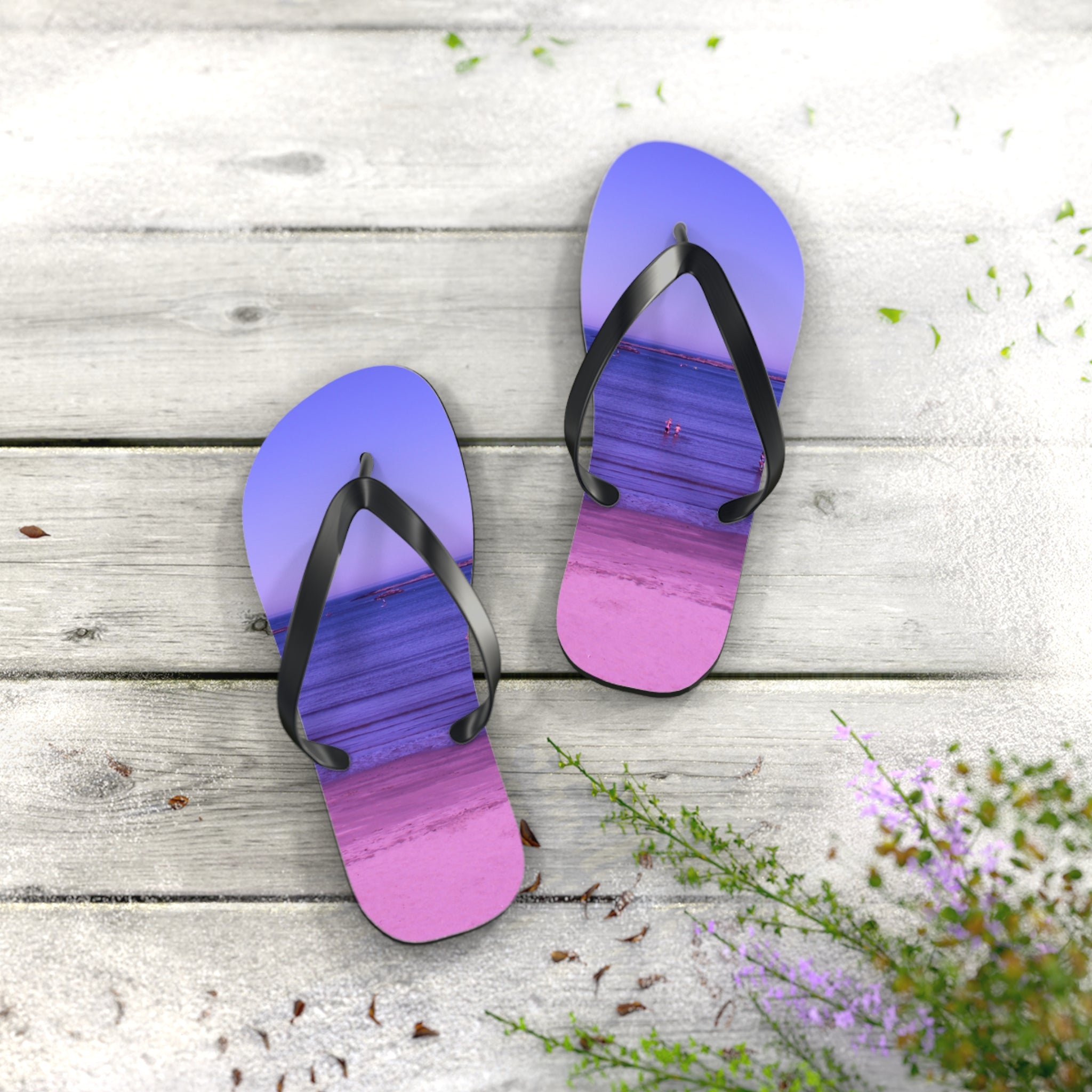 Purple and pink ombre flip-flops with beach scene on wooden planks.