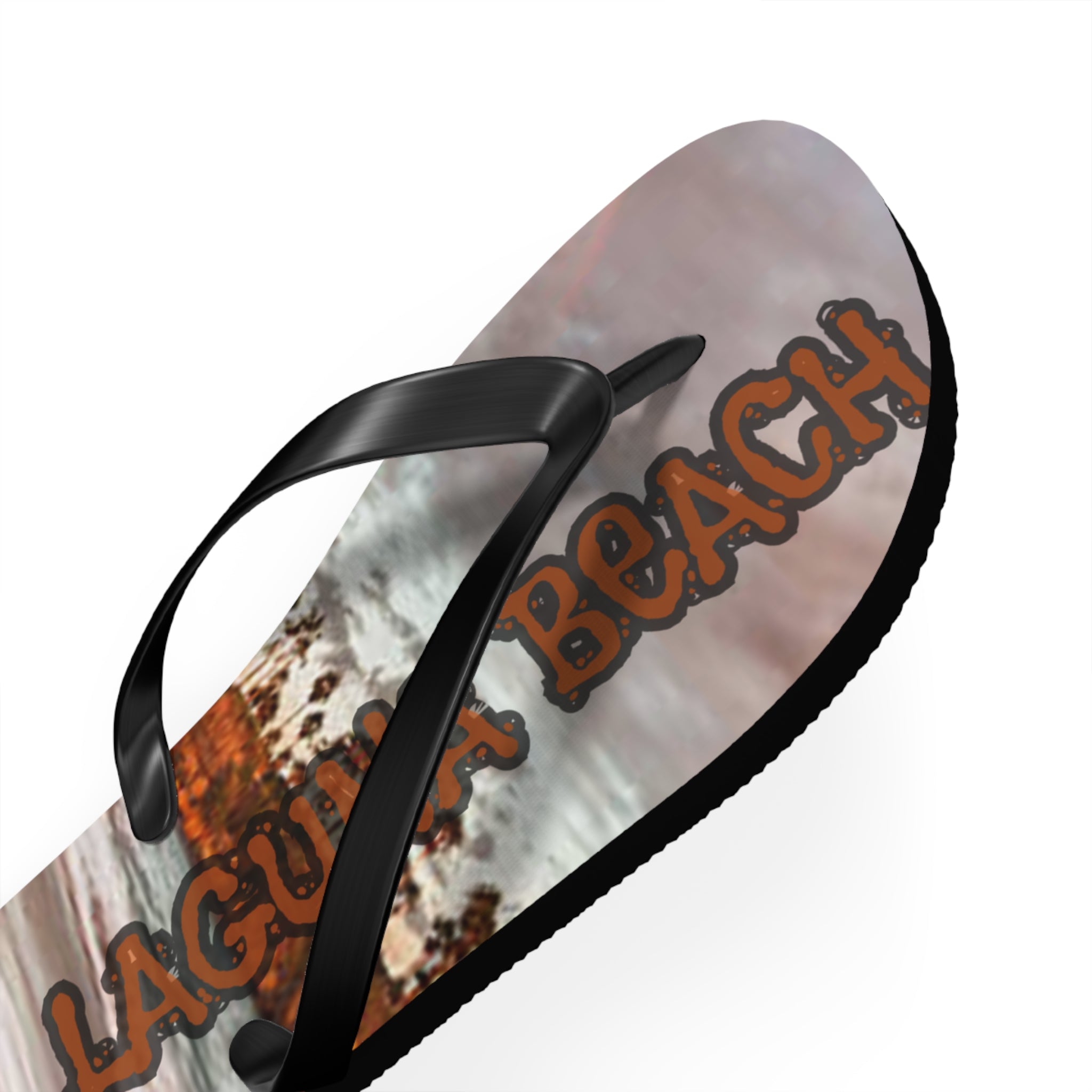Flip-flop with "Laguna Beach" text over a textured, rustic background.