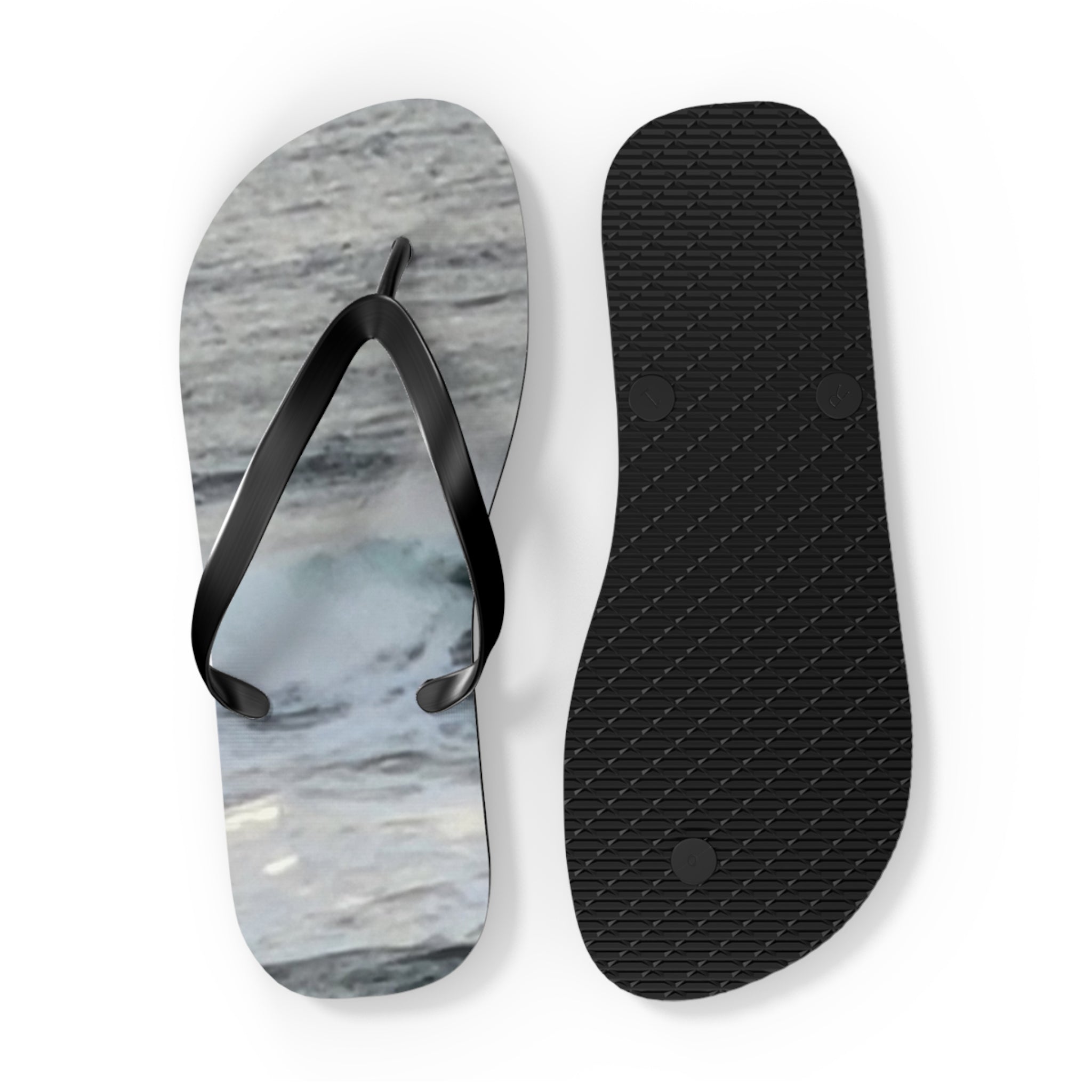 Flip-flops with ocean wave design on straps and textured black soles.