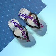 Flip-flops with "LAGUNA BEACH" text in purple and pink on a blue patterned background.