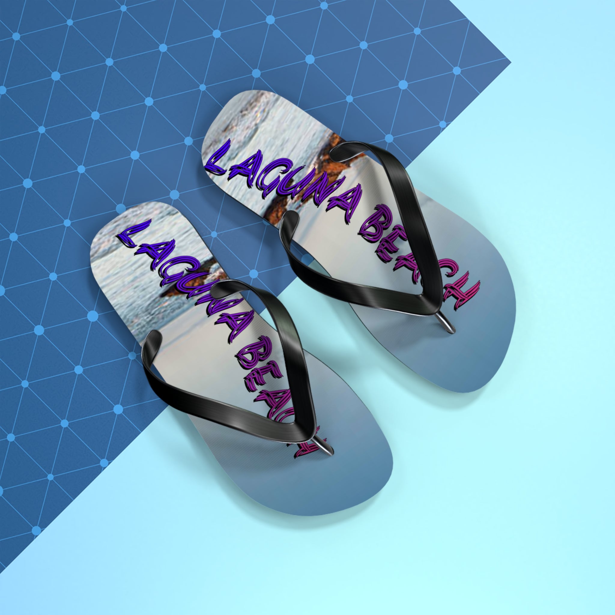 Flip-flops with "LAGUNA BEACH" text in purple and pink on a blue patterned background.