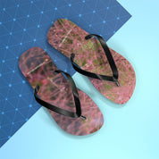 Flip flops with pink floral pattern on blue grid background.