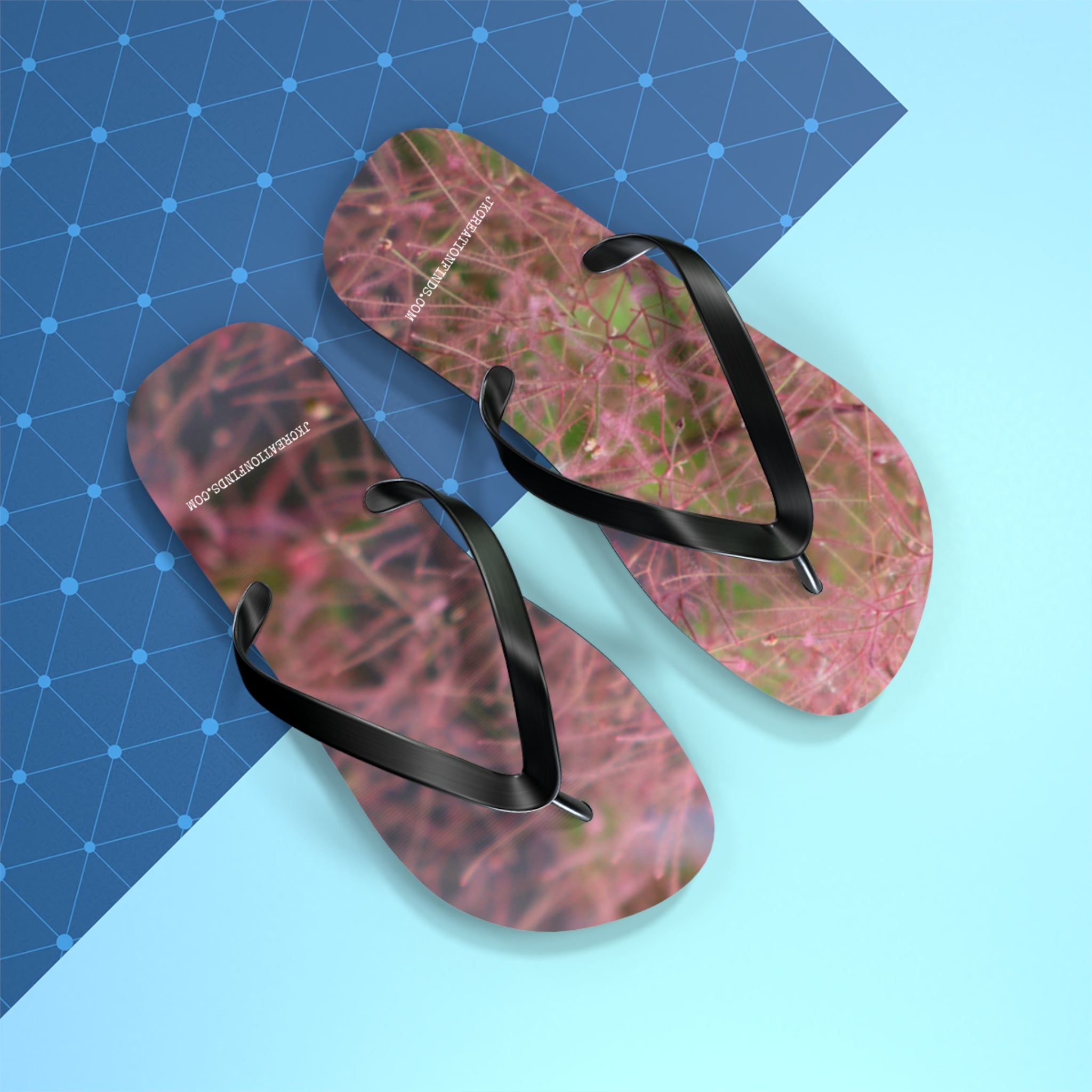 Flip flops with pink floral pattern on blue grid background.