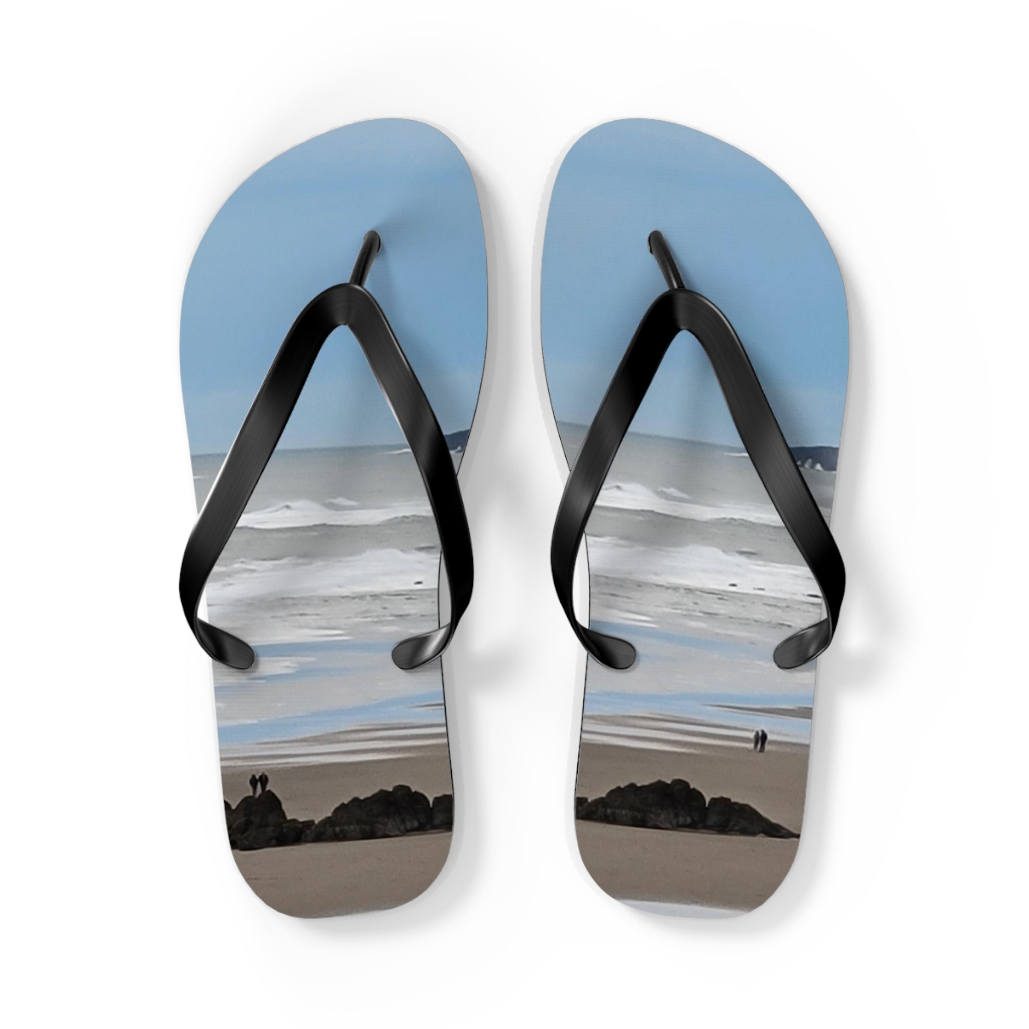 Flip-flops with a beach scene featuring waves and two people.
