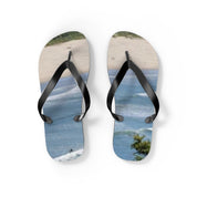 Flip-flops with a beach and ocean scene printed on the soles.