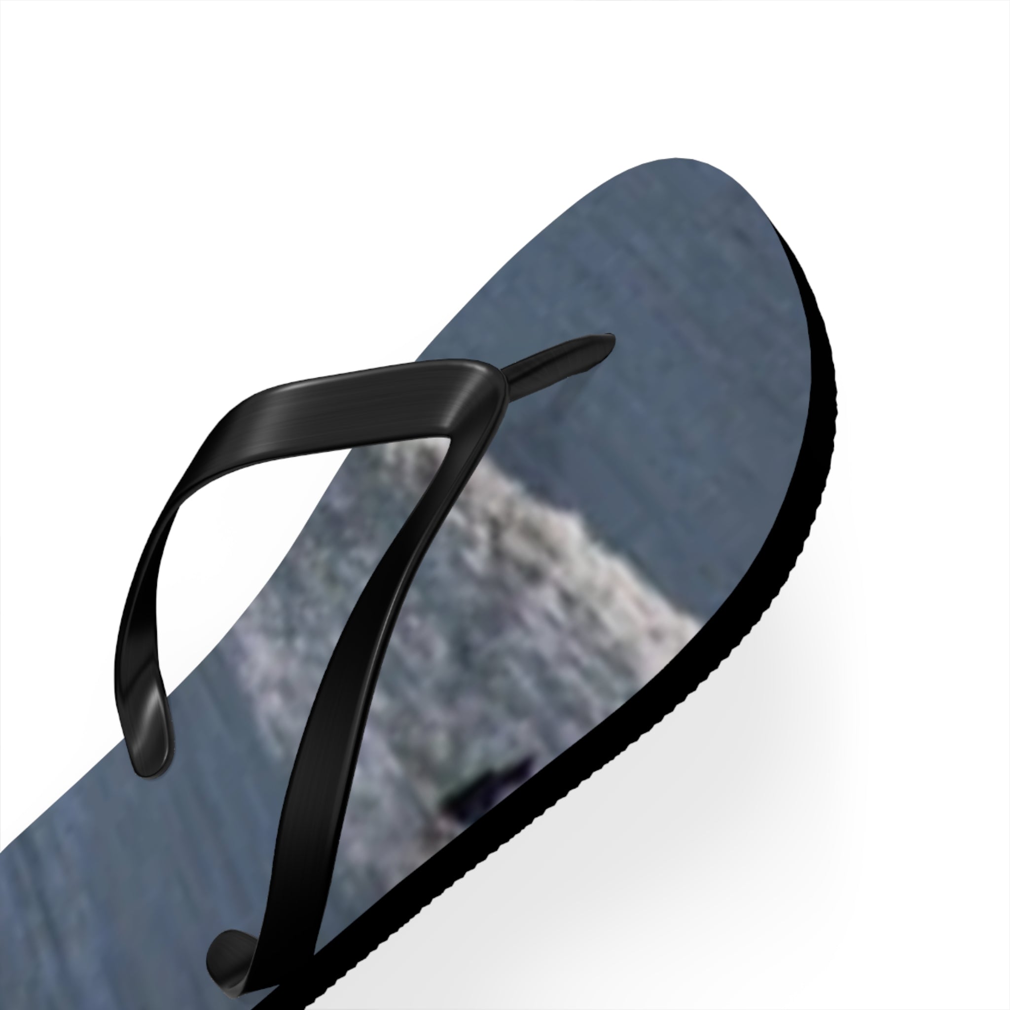 Black flip-flop with a gray and white textured sole and a white background.