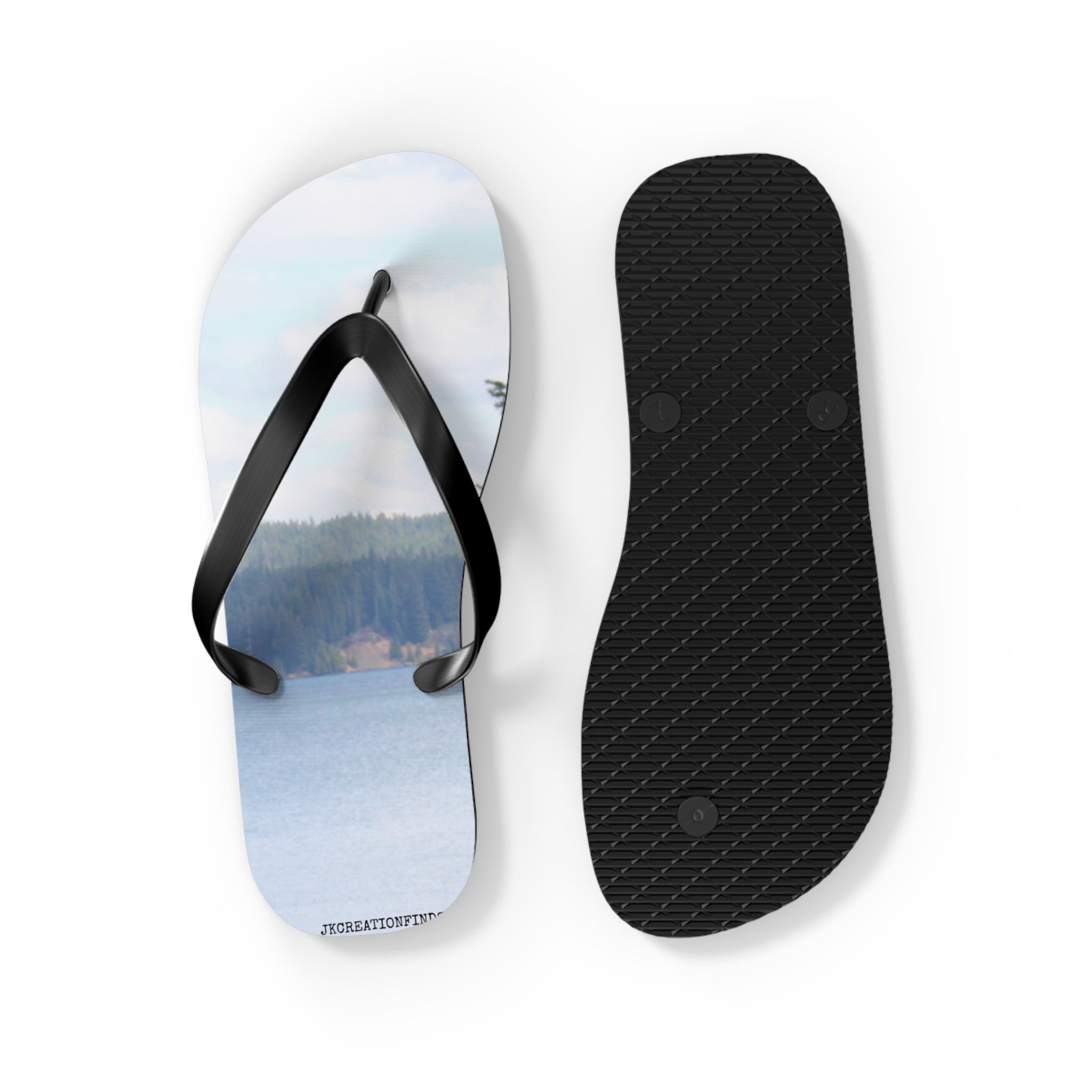 Black flip-flops with a scenic lake and forest image on one sole.