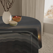 Round tablecloth with a sunset landscape scene over a table.