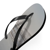 Black flip-flop with a beach scene on the sole.