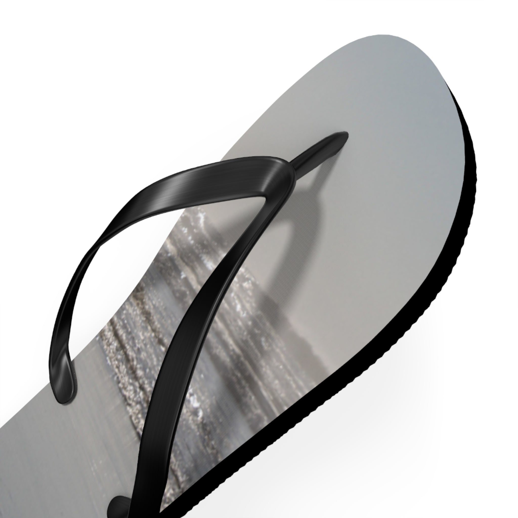 Black flip-flop with a beach scene on the sole.