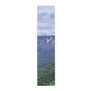 Mountain landscape with trees and clouds.