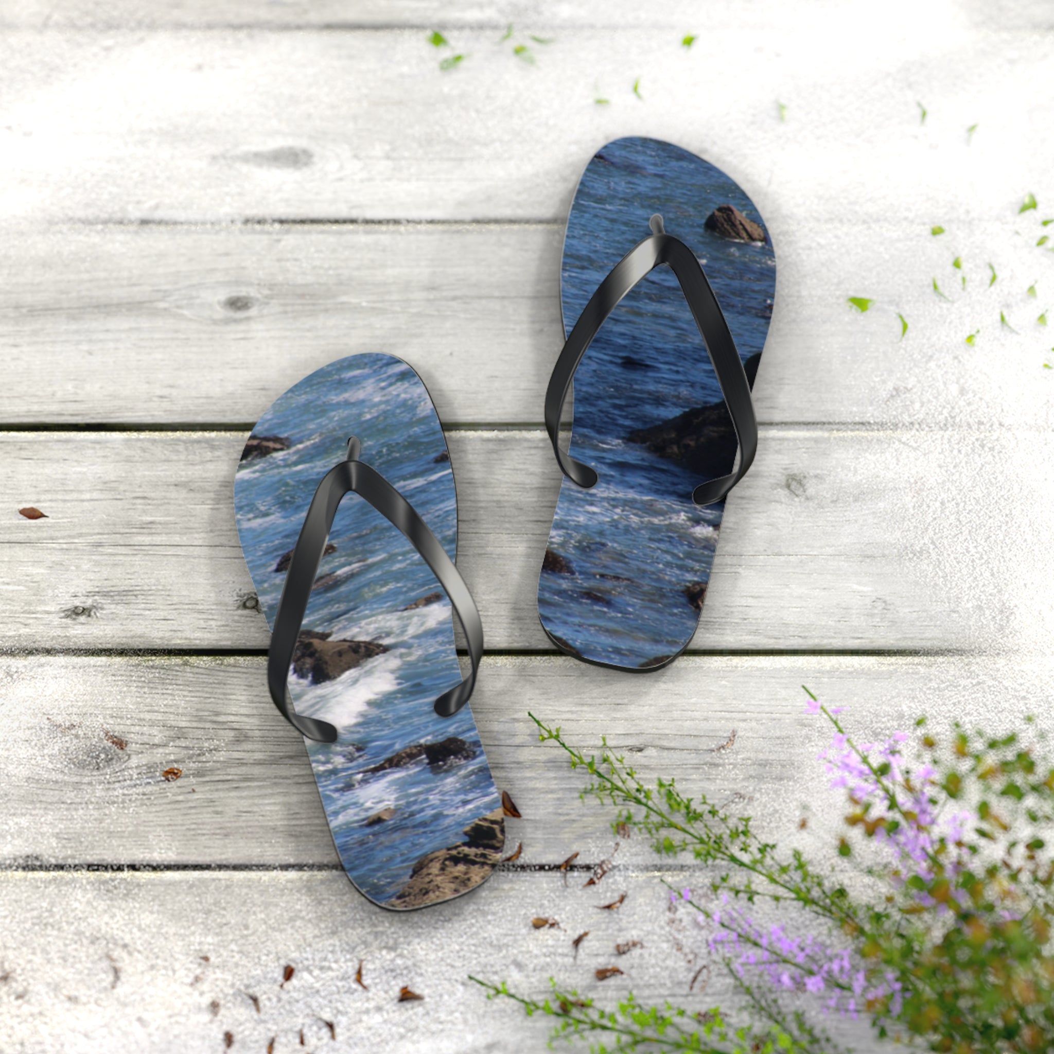 Flip-flops with ocean wave design on a wooden surface.