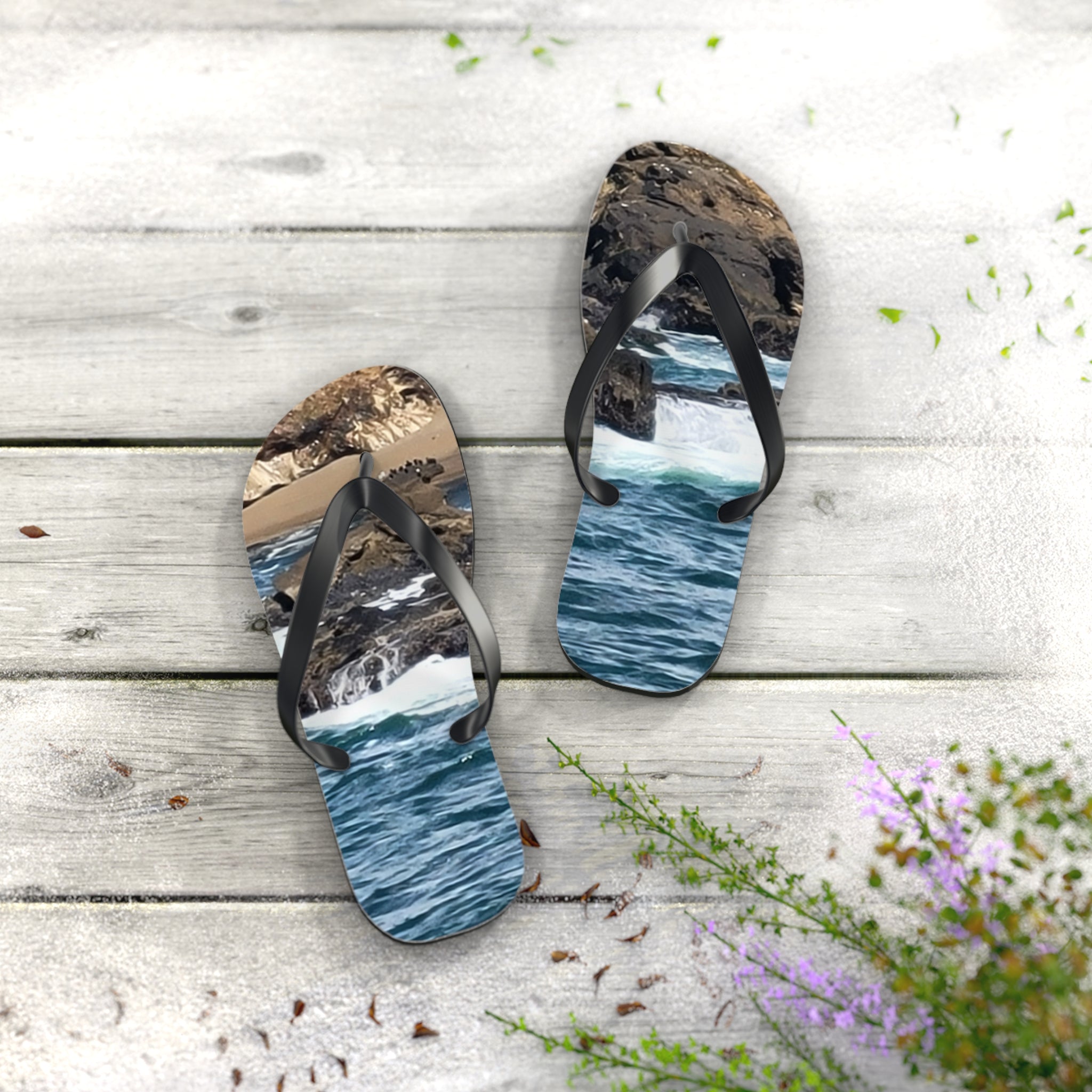 Flip flops with ocean waves and rocks design on a wooden surface.