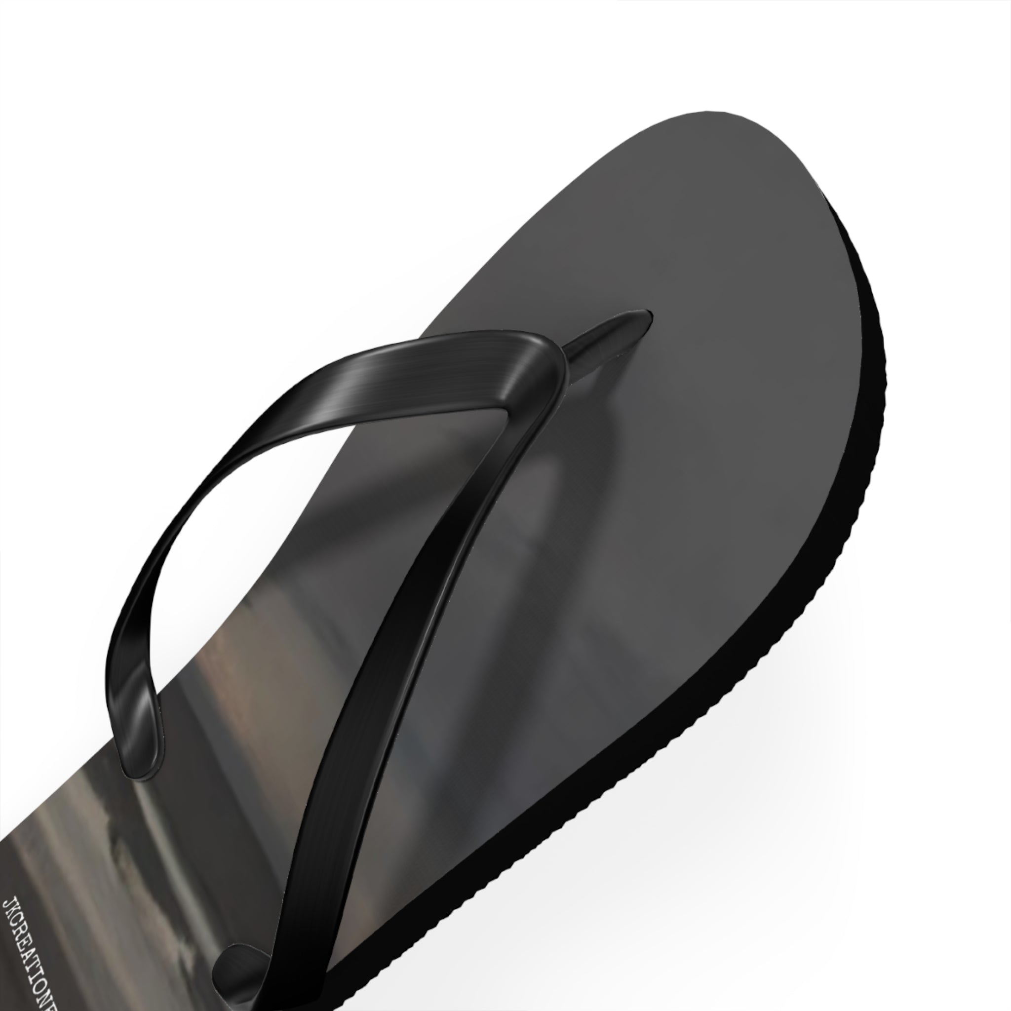 Black flip-flop with a reflective surface and white background.