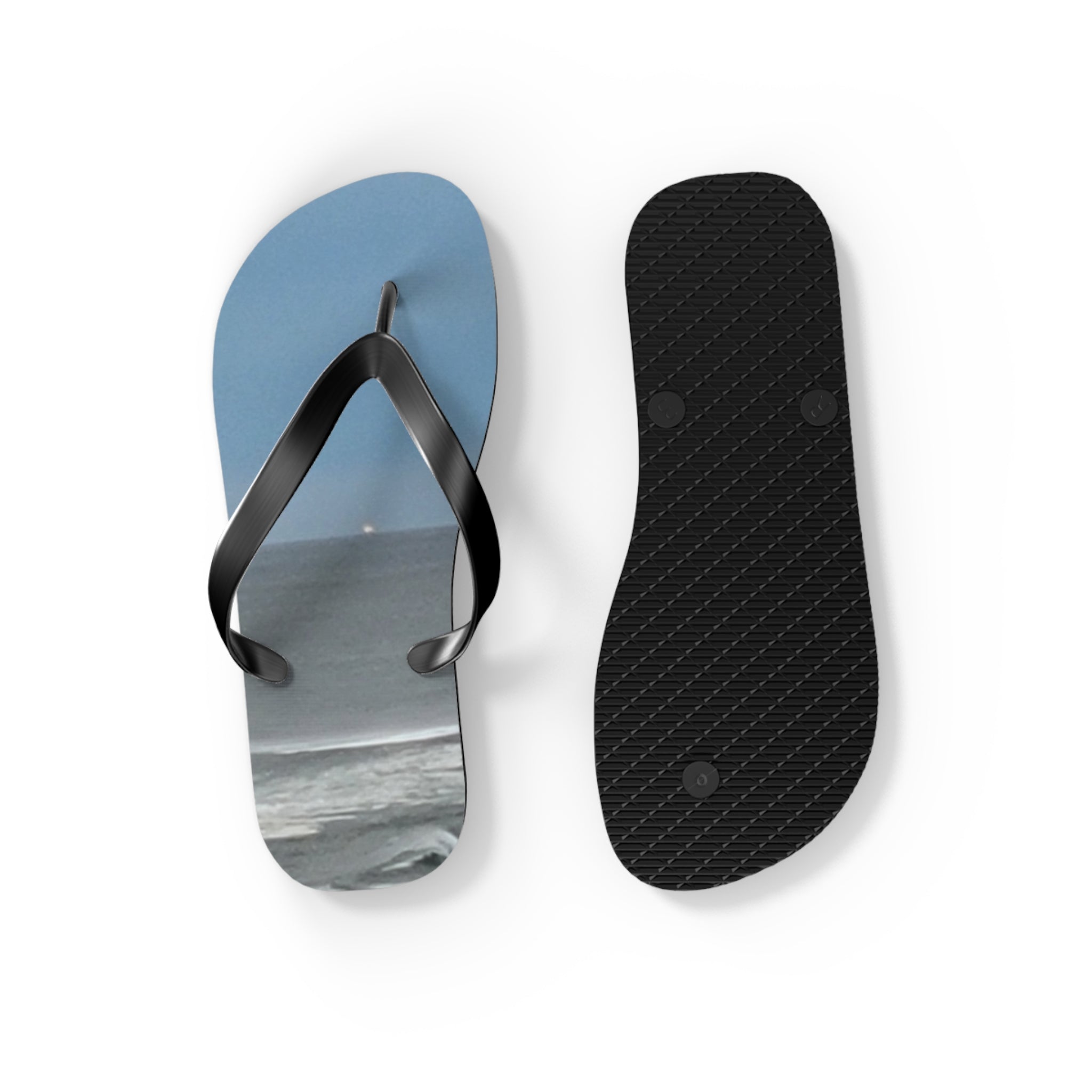 Flip flops with a beach and water scene on the left strap.