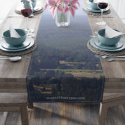 Table runner with a distant forest and village landscape and "JKCREATIONFINDS.COM" text.