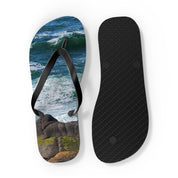 Flip-flops with ocean waves and rocky shore design on white background.