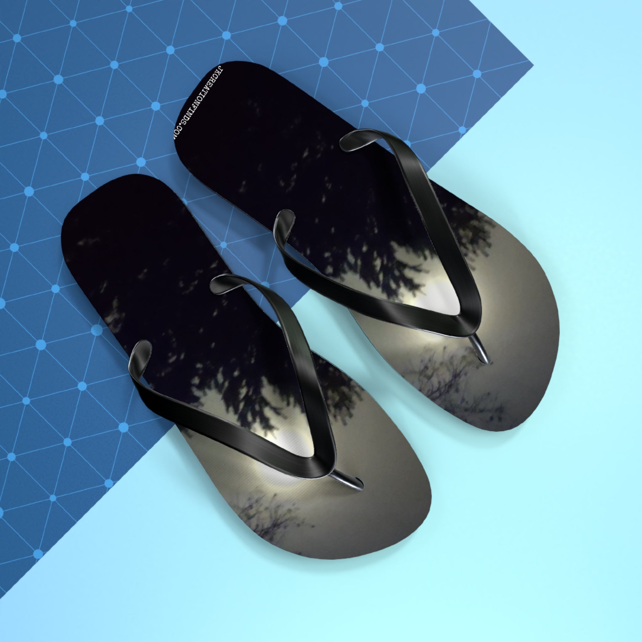 Black flip-flops with a starry night sky and tree silhouette design.