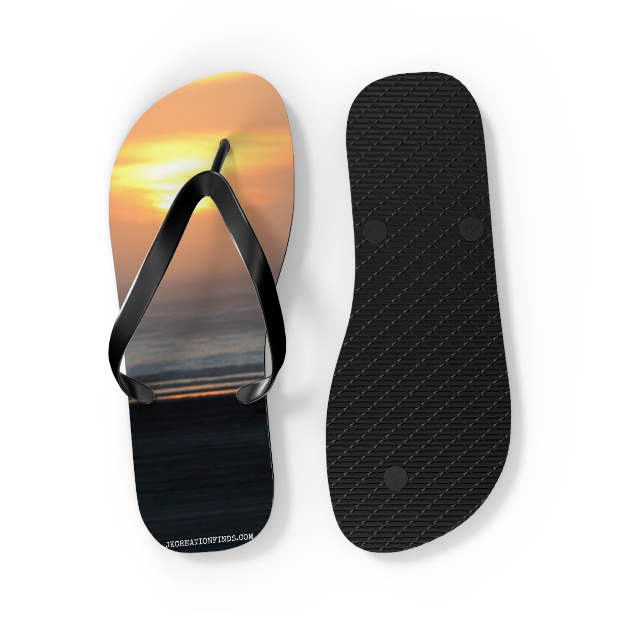 Flip flops with a sunset beach scene on one, black sole on the other.