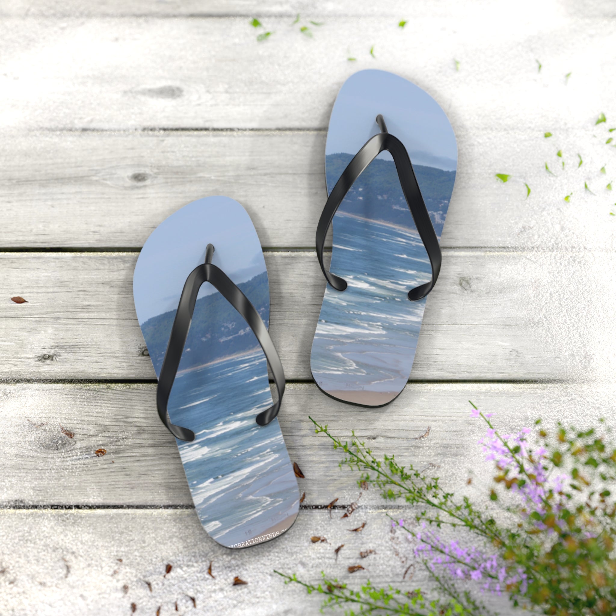 Flip-flops with a scenic ocean view on a weathered wooden deck.