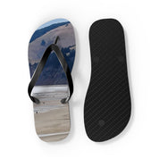 Flip flops with a beach landscape on one sole and textured black on the other.