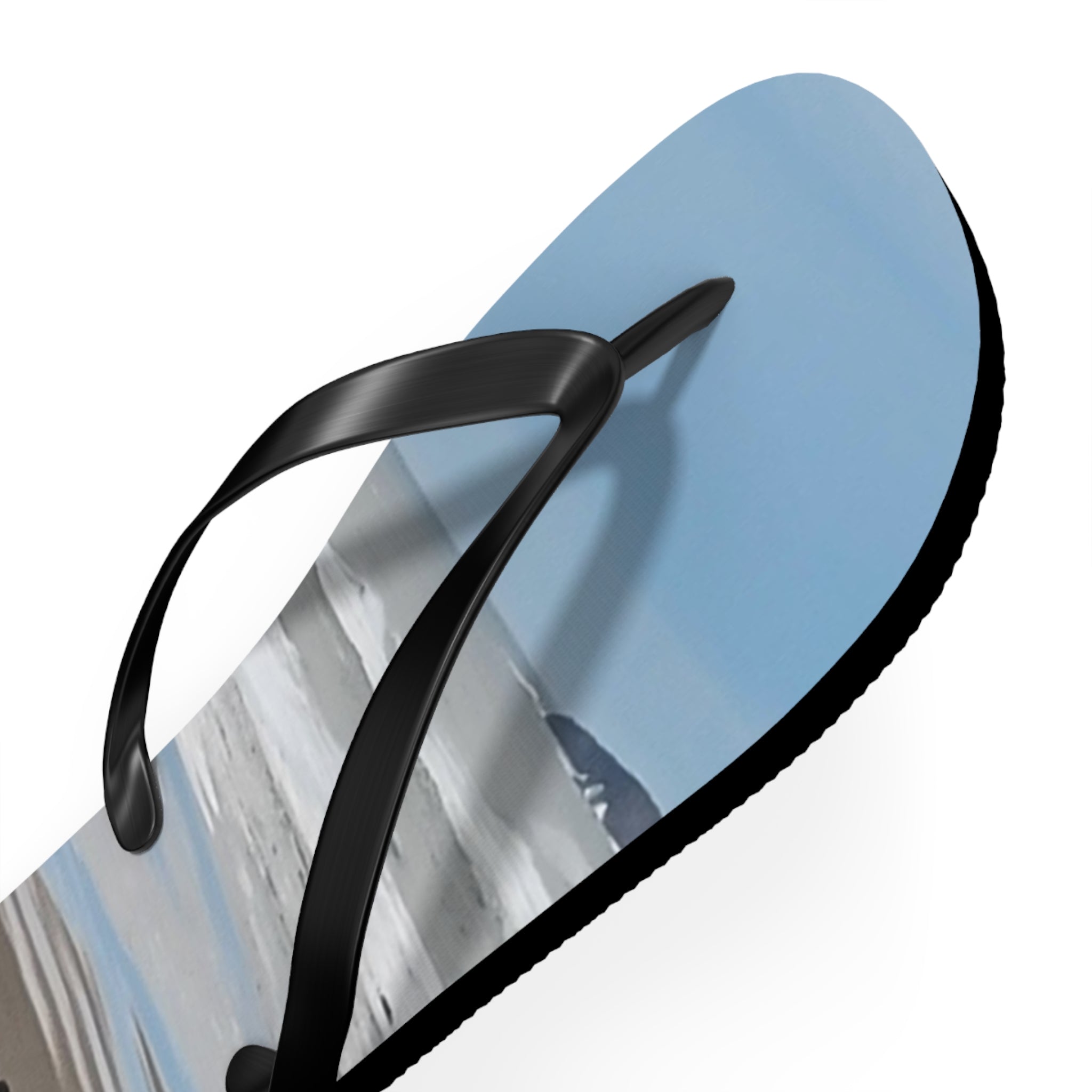 Black flip-flop with a beach landscape printed on the sole.