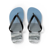 Blue flip-flops with ocean waves on a white background.