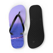 Purple flip-flops with ocean scene on left and black sole on right.