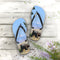 Flip-flops with a landscape scene of stone structures and mountains.