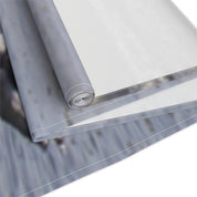 Rolled fabric with a blurred background of gray and white textures.