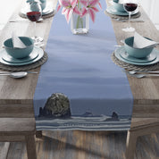 Table runner with ocean rocks and lilies on a dining table.