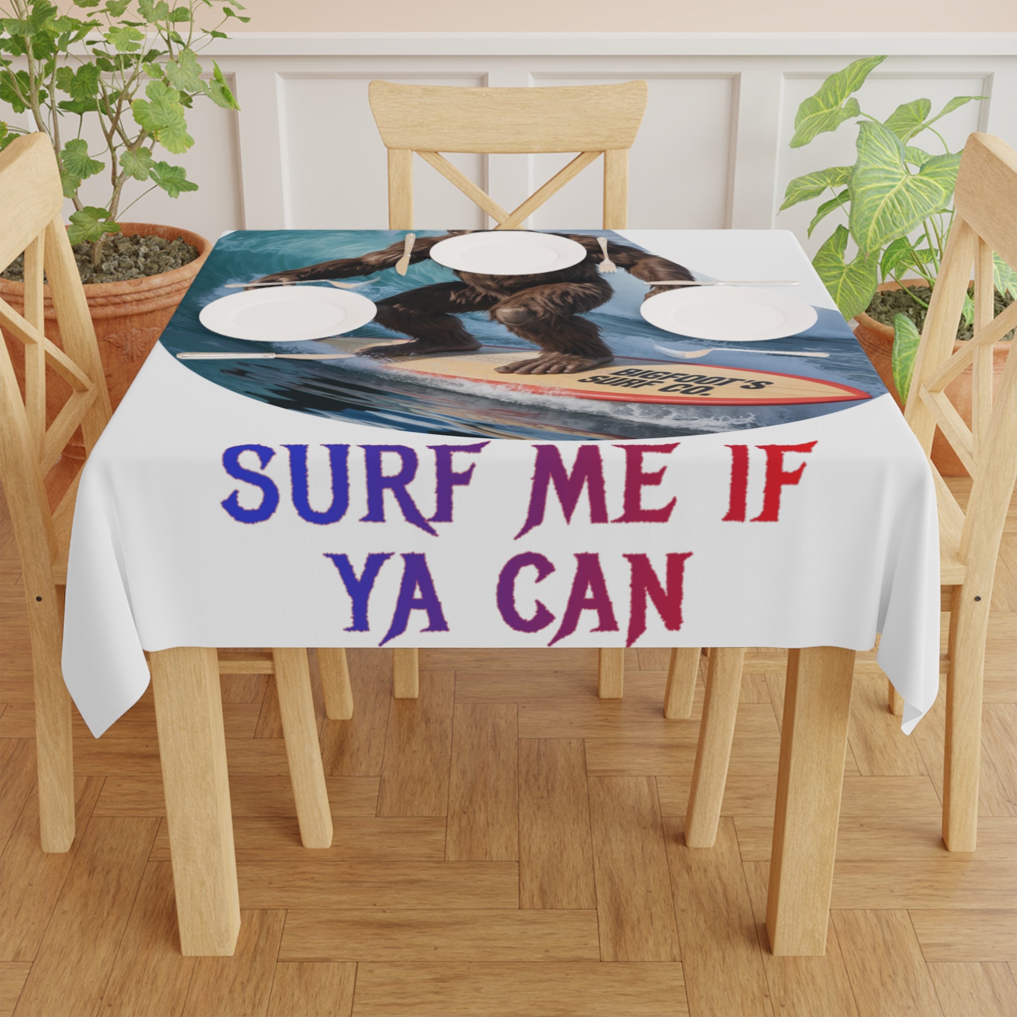Bigfoot surfing on a tablecloth with "SURF ME IF YA CAN" text.