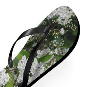 Flip-flop with white flowers and green leaves pattern.