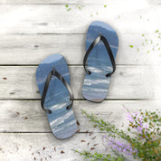 Flip-flops with a beach and ocean scene on a wooden surface.