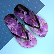 Purple floral flip-flops with black straps on a blue background.