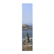 Coastal rock formations and ocean under a clear blue sky.