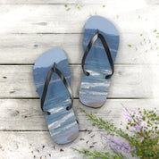 Flip-flops with a beach scene, resting on weathered wooden planks.